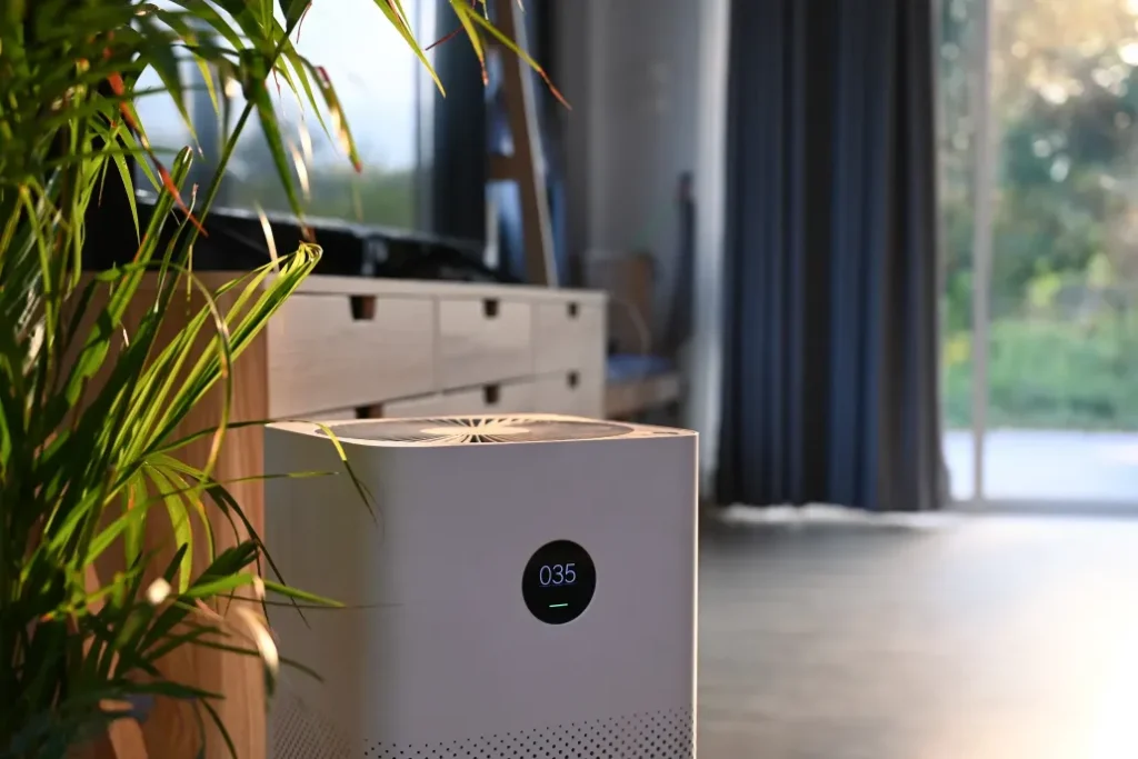 Air purifier with digital monitor screen and house plant in living room 
