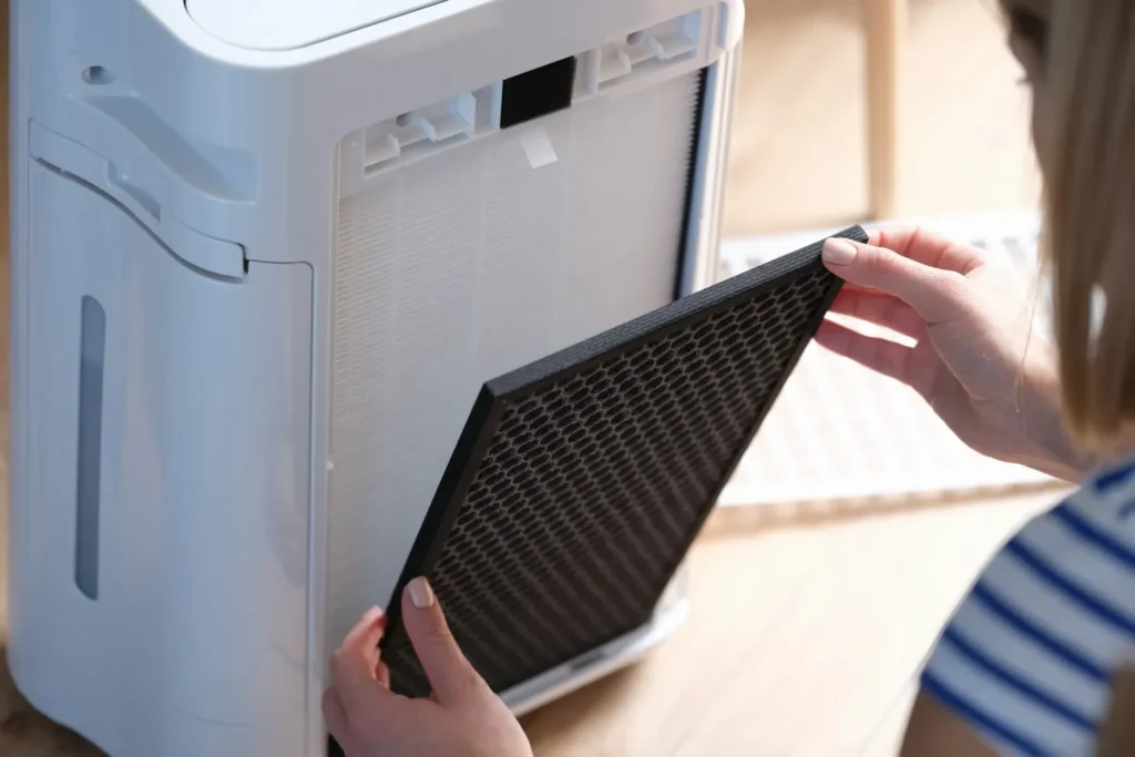 Cleaning guide for Levoit air purifier: Woman removing the filter from the air purification system