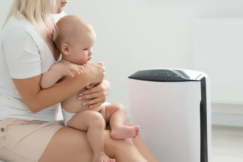 Mother and baby enjoying clean air near an air purifier at home