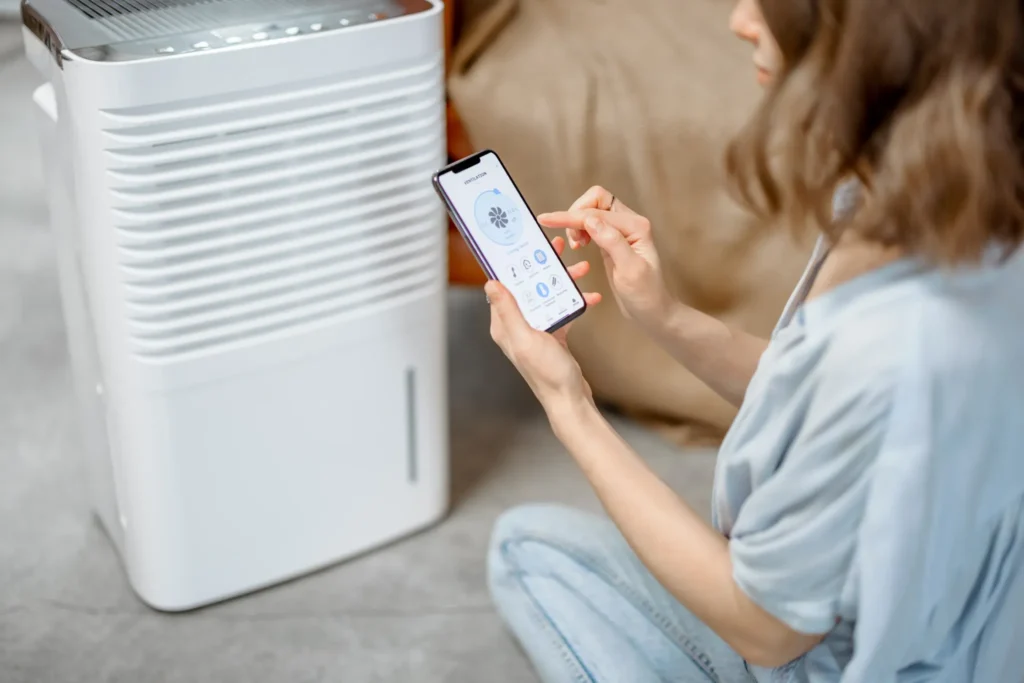 Woman sitting near an air purifier and moisturizer appliance 