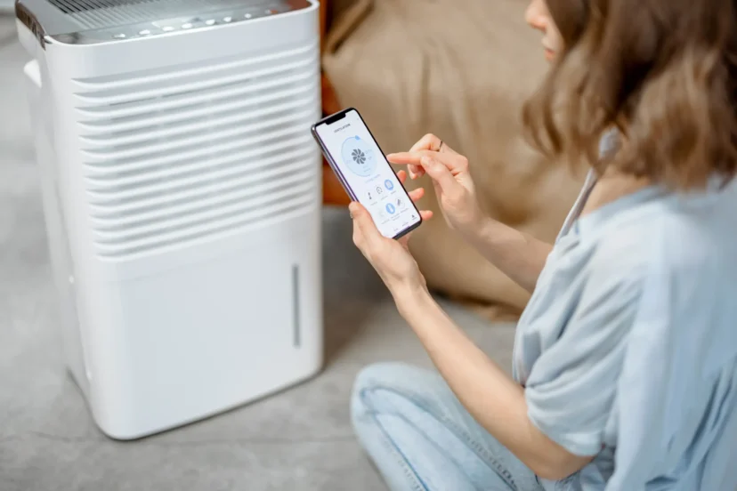 Woman sitting comfortably next to an air purifier and moisturizer appliance