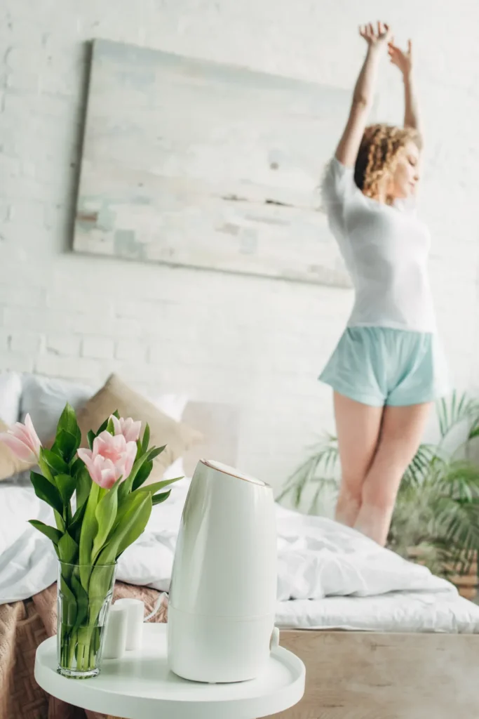 Woman stretching in bedroom with air purifier and flowers 