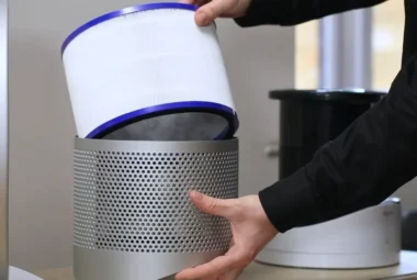 A person carefully cleaning a Dyson air purifier filter, illustrating a step-by-step guide