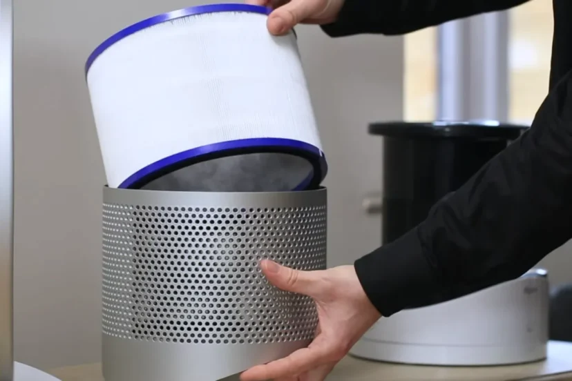 A person carefully cleaning a Dyson air purifier filter, illustrating a step-by-step guide